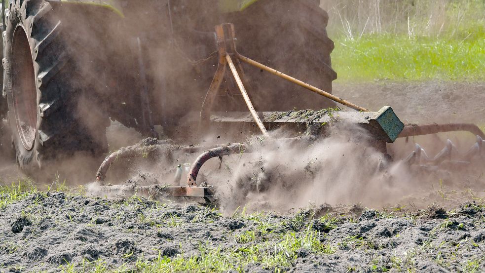 Ein Trecker wirbelt beim Bearbeiten eines Ackers ordentlich Staub auf. Durch den Regen in den vergangenen Tagen hat sich die Situation für die Landwirte etwas entspannt. Foto: Ortgies