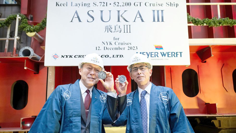 Hisaya Higuchi (NYK Line) und Yoshiharu Tsutsumi (NYK Cruises) platzierten in Papenburg Münzen unter dem Kiel der „Asuka III“. Foto: Meyer-Werft