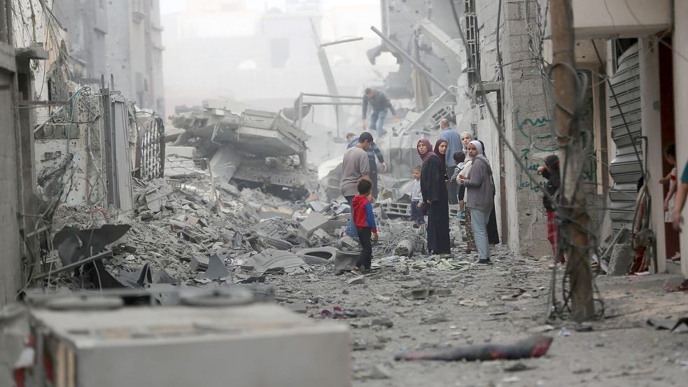 Menschen versammeln sich auf den Trümmern eines zerstörten Gebäudes nach einem Luftangriff im Flüchtlingslager Maghazi im Zentrum des Gazastreifens. Foto: Uncredited/XinHua/dpa