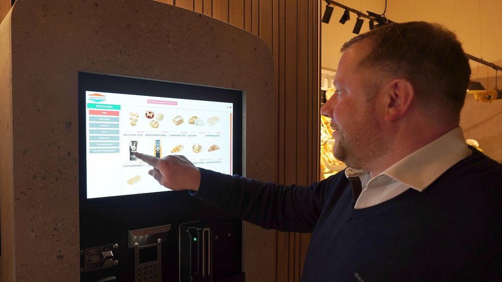 Prokurist Marcus Meier demonstriert, wie die einzelnen Produkte am „Backje“ per Touchscreen auf einem Terminal am Automaten bestellt werden können. Fotos: Roispich