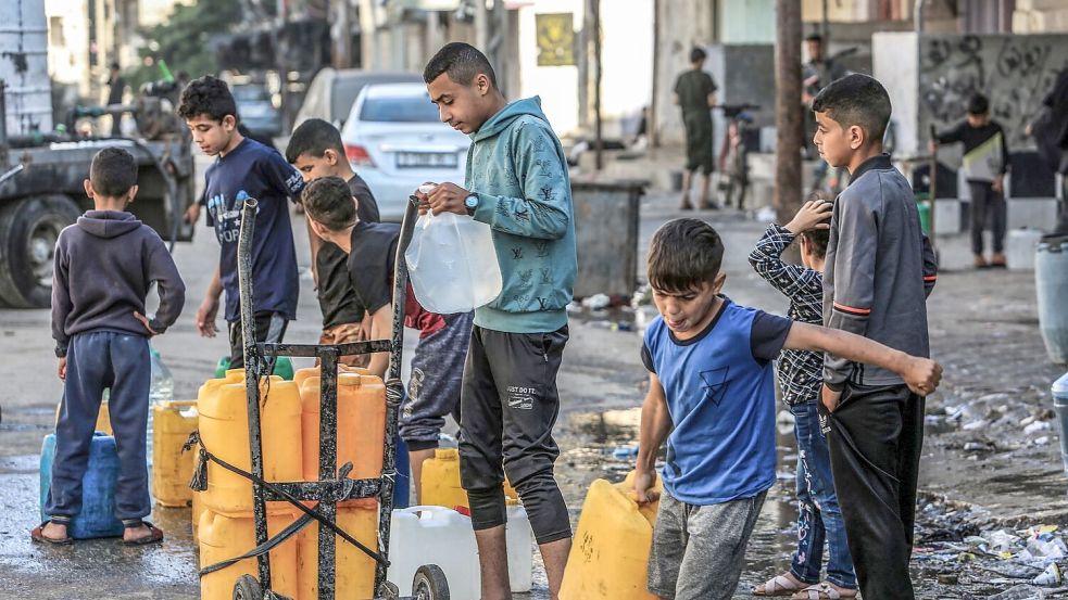 Palästinensische Kinder stehen mit Wasserbehältern Schlange, um sie mit Trinkwasser zu füllen. Foto: Abed Rahim Khatib/dpa