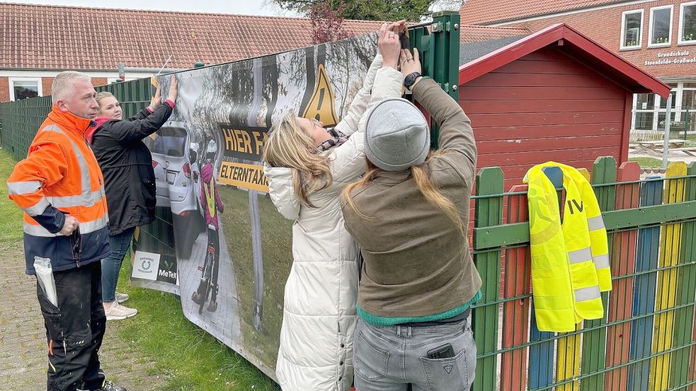 Mitglieder der „Interessengemeinschaft Verkehrssicherheit Schulstraße (IVS)“ haben am Zaun der Grundschule bereits Banner angebracht. Foto: Ammermann