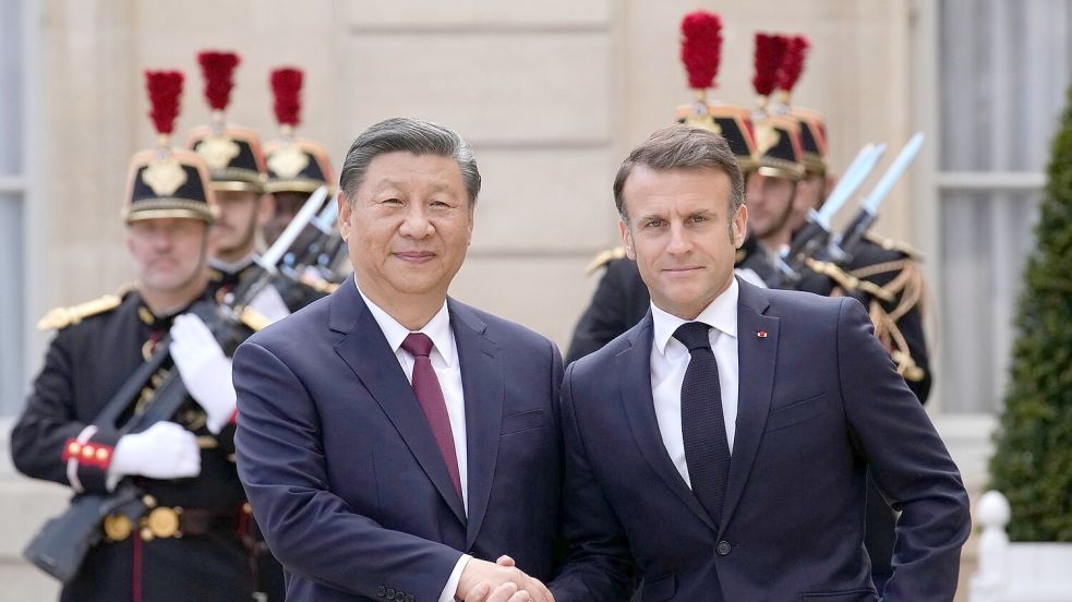 Der französische Präsident Emmanuel Macron (r) begrüßt Chinas Präsident Xi Jinping vor ihrem Treffen im Elysee-Palast. Foto: Christophe Ena/AP/dpa