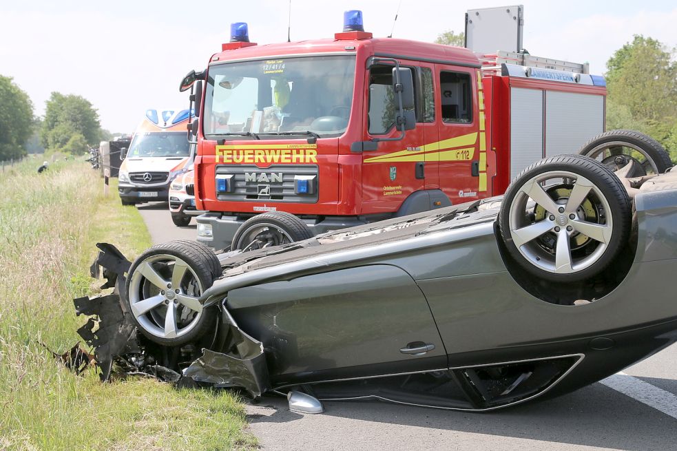 Der Audi überschlug sich. Im Hintergrund ist der umgekippte Wohnwagen zu sehen. Bild: Loger