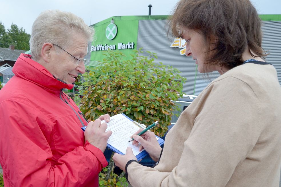 Doris Block aus Scharrel unterschreibt bei Walter Hußmann für das Bürgerbegehren.