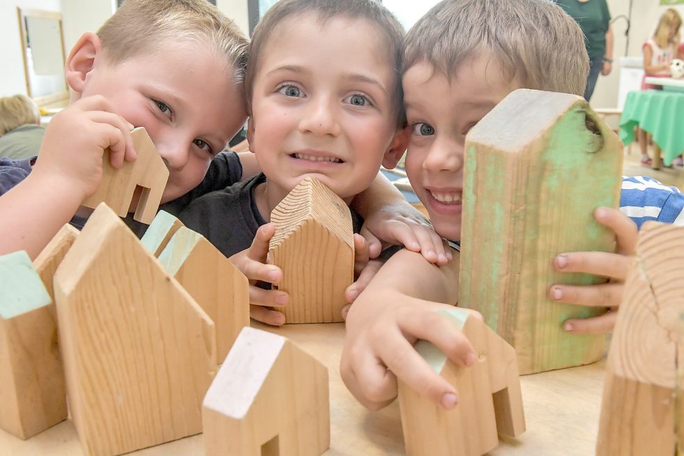 Stefan (von links), Christer und Fabian bauen in der Pinguin-Kindertagesstätte in Aurich mit Häusern aus Holz. Gebaut werden müsste auch in vielen Kommunen Ostfrieslands – denn es fehlen Plätze. Foto: Ortgies