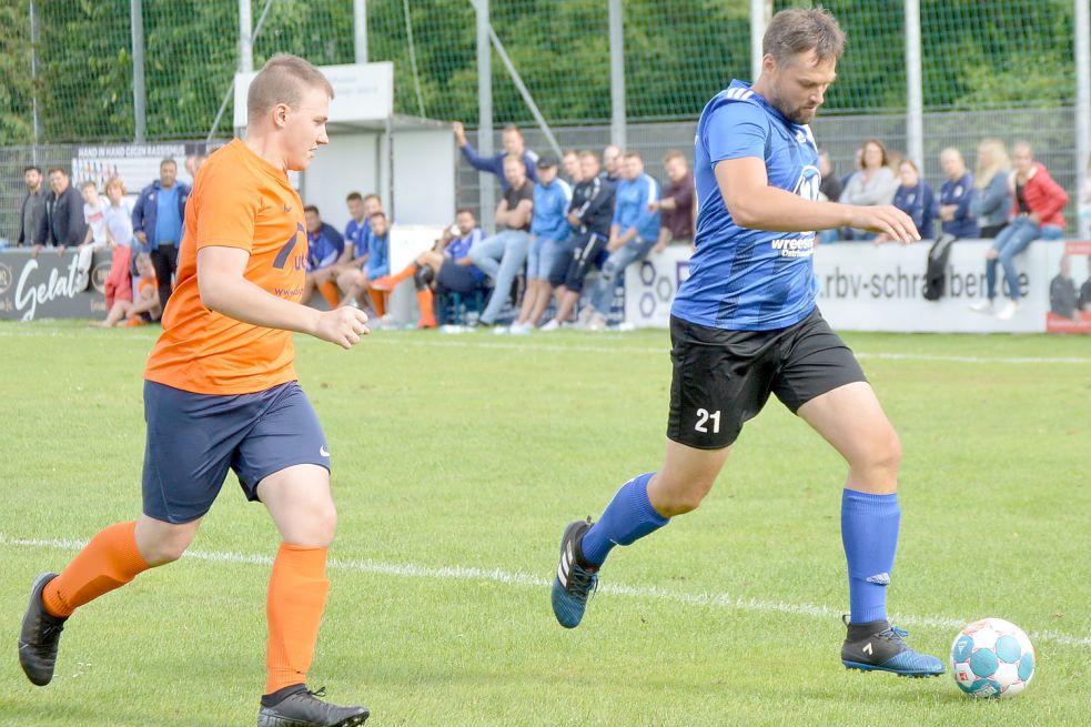 Der eingewechselte Ostrhauderfehner Ralf Hillmer (blaues Trikot) versucht hier, mit dem Ball zu enteilen. Foto: Weers
