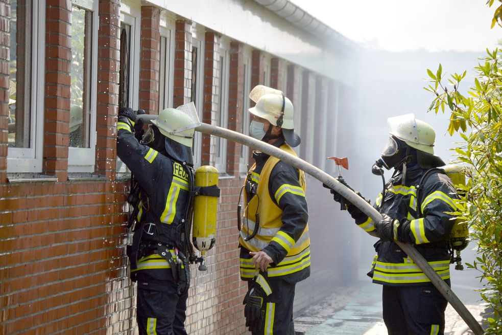 Durch Fenster wird in den Innenräumen das Feuer bekämpft. Foto: Weers
