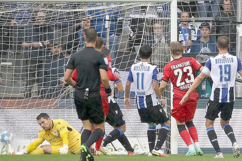 Bielefelds Torwart Stefan Ortega (l) kassiert den Gegentreffer zum 0:1 durch Frankfurts Jens Petter Hauge (2.v.r). Foto: Friso Gentsch/dpa