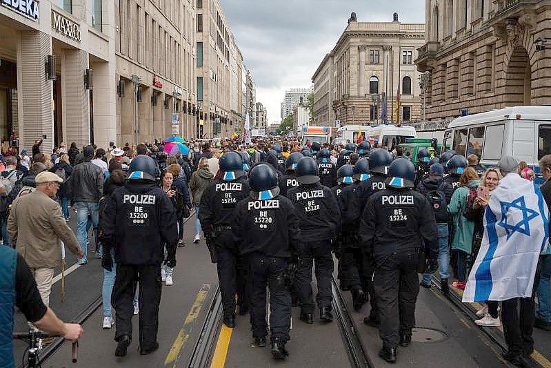 Polizisten folgen nach dem Ende einer Kundgebung gegen die Corona-Politik der Regierung den Teilnehmern. Foto: Paul Zinken/dpa