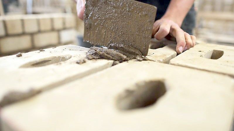 Ein Auszubildender zum Maurer arbeitet im Ausbildungszentrum Butzweilerhof an einer Mauer. Foto: Oliver Berg/dpa