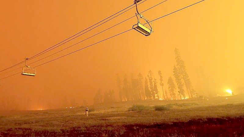 Ein Skilift im Skigebiet Sierra-at-Tahoe vor dem Hintergund des Caldor-Feuers. Foto: Noah Berger/AP/dpa