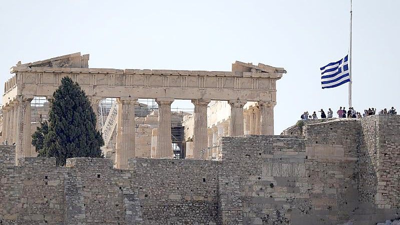 Die griechische Flagge weht nach dem Tod des griechischen Komponisten Mikis Theodorakis vor dem Parthenon-Tempel auf Halbmast. Foto: Thanassis Stavrakis/AP/dpa