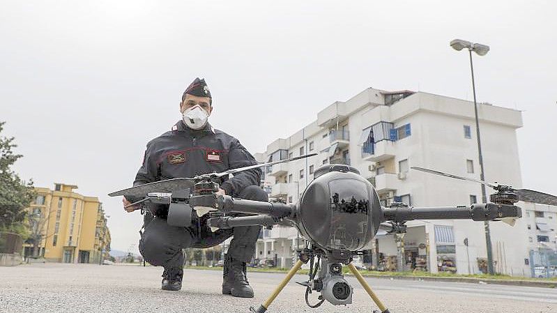 Ein Offizier der Carabinieri manövriert im Stadtviertel Scampia, Neapel, eine Drohne, um die Bewegungen der Menschen zu kontrollieren. (Archivbild). Foto: Fabio Sasso/LaPresse/dpa