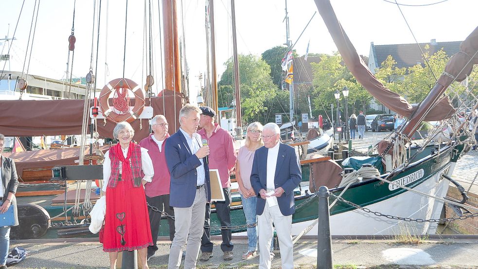 Hohe Ehre für den Ewer „Friedrich“: Peter Südbeck (mit Mikrofon) und Günter Prahm (rechts) besiegelten die Zusammenarbeit der Schiffergilde mit dem Unesco Naturerbe Niedersächsisches Wattenmeer. Foto: Wolters