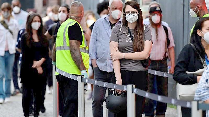 Menschen stehen beim Impfzentrum in Berlin-Treptow an. Im weiteren Kampf gegen die Corona-Pandemie will der Bundestag noch kurz vor der Wahl einige Neuregelungen beschließen. Foto: John Macdougall/AFP POOL/dpa