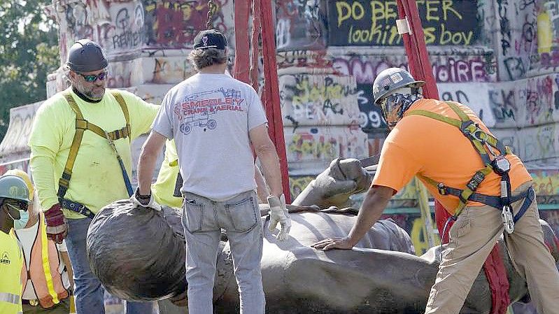 Arbeiter senken vorsichtig den Torso einer Bronzefigur des Südstaaten-Generals Robert Edward Lee. Foto: Steve Helber/AP/dpa