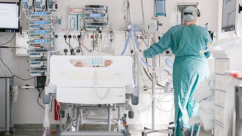 Eine Intensivpflegerin versorgt auf einer Intensivstation einen an Covid-19 erkrankten Patienten (Archivbild). Foto: Ole Spata/dpa