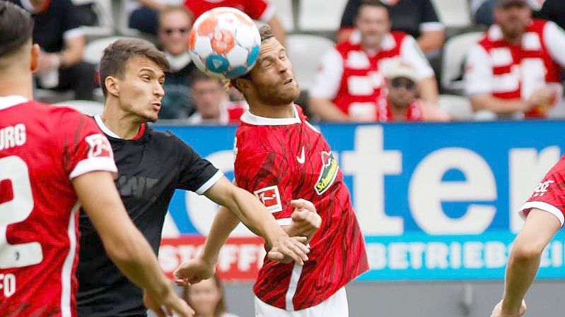 Kölns Dejan Ljubicic (l) und Freiburgs Lucas Höler im Kopfballduell. Foto: Philipp von Ditfurth/dpa