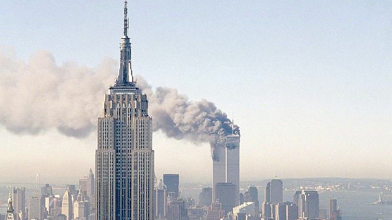 Die Zwillingstürme des World Trade Centers brennen hinter dem Empire State Building. Am 11. September 2001 hatten islamistische Terroristen drei gekaperte Flugzeuge in das World Trade Center in New York und das Pentagon in Washington gesteuert. Foto: Marty Lederhandler/AP/dpa