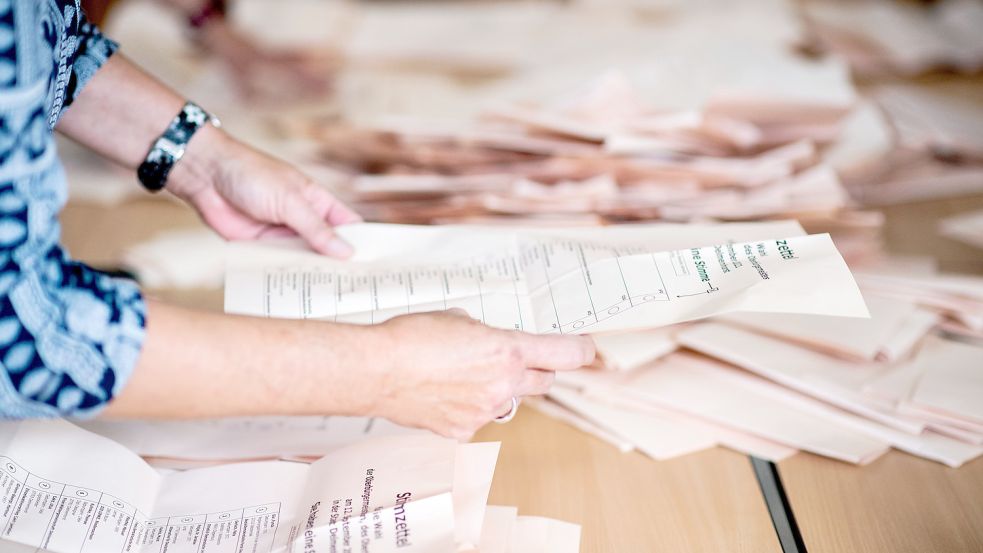 Die Wahlhelferinnen und Wahlhelferinnen in Uplengen hatten alle Hände voll zu tun, um die Stimmzettel für die Auszählung zu sortieren. Foto: Dittrich/dpa