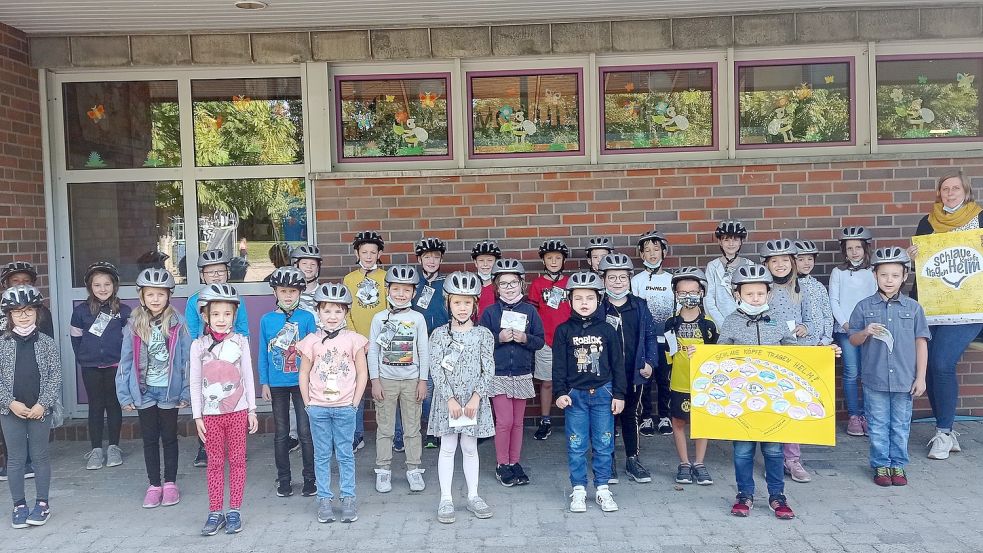 Kinder aller vier Jahrgänge der Grundschule Ramsloh präsentieren gemeinsam mit der Schulelternratsvorsitzenden, Daniela Willer (rechts), ihre neuen Fahrradhelme. Foto: Schule