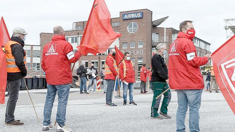 Mitarbeiter im Warnstreik vor dem Haupteingang von Airbus in Hamburg-Finkenwerder. Foto: Markus Scholz/dpa