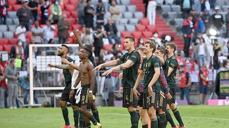 Bayerns Spieler feiern nach der fulminanten Partie den Sieg gemeinsam mit den Fans. Foto: Sven Hoppe/dpa