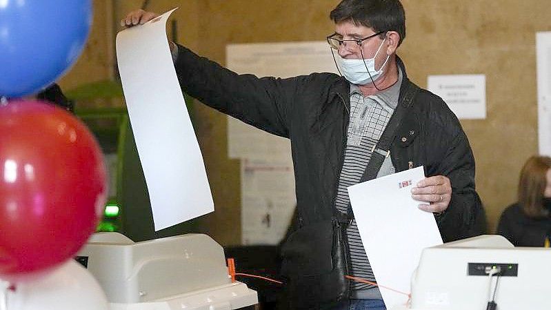 Ein Mann gibt in einem Wahllokal in Moskau seine Stimme ab. Foto: Alexander Zemlianichenko/AP/dpa