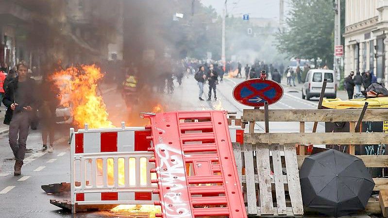 Eine Barrikade brennt in Leipzig. Nach Ende einer linken Demonstration war es zu Ausschreitungen gekommen. Foto: Jan Woitas/dpa-Zentralbild/dpa