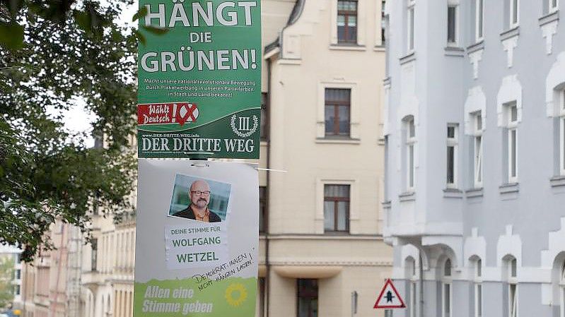 Ein umstrittenes Wahlplakat der Splitterpartei Der Dritte Weg hängt in Zwickau über einem Plakat der Grünen (Archivbild). Foto: Bodo Schackow/dpa-Zentralbild/dpa