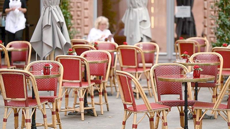 Viele freie Tische vor einem Café in Frankfurt. Foto: Arne Dedert/dpa