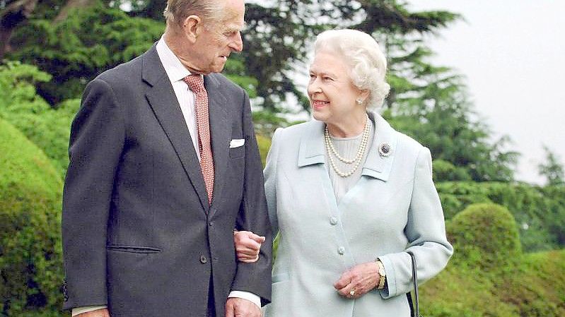 Queen Elizabeth II. und Prinz Philip, Herzog von Edinburgh, stehen in der Gartenanlage von Broadlands in England. (Archivbild). Foto: Fiona Hanson/PA Wire/dpa