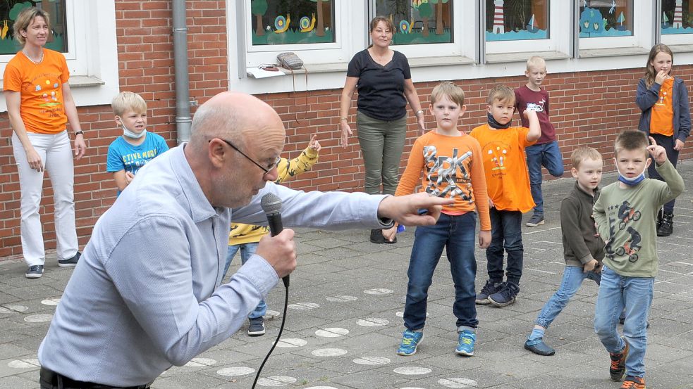 Musik-Pädagoge Remmer Kruse übte im Beisein von Schulleiterin Silke Abbes (links) das neue Schullied mit den Kindern ein. Foto: Zein
