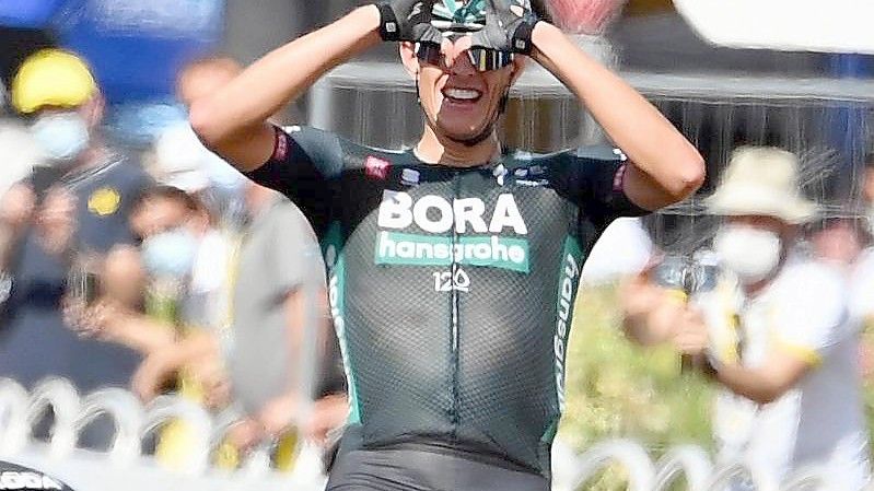 Nils Politt formt nach seinem Tagessieg bei der Tour de France mit den Händen im Ziel ein Herz. Foto: David Stockman/BELGA/dpa