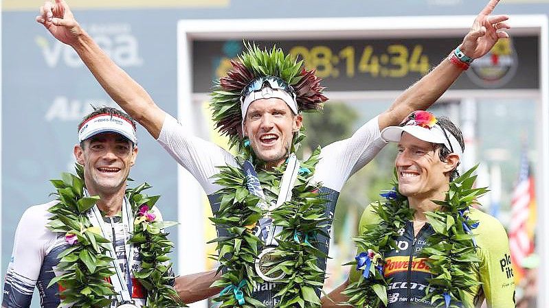 Jan Frodeno (M) feiert auf Hawaii beim letzten Ironman 2019 seinen Sieg. Foto: David Pintens/BELGA/dpa