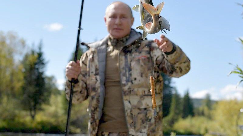 Auch in diesem Jahr wieder unter den Motiven aus Putins Sommerurlaub: Russlands Präsident mit Fisch an der Angel. Foto: Alexei Druzhinin/Pool Sputnik Kremlin/AP/dpa