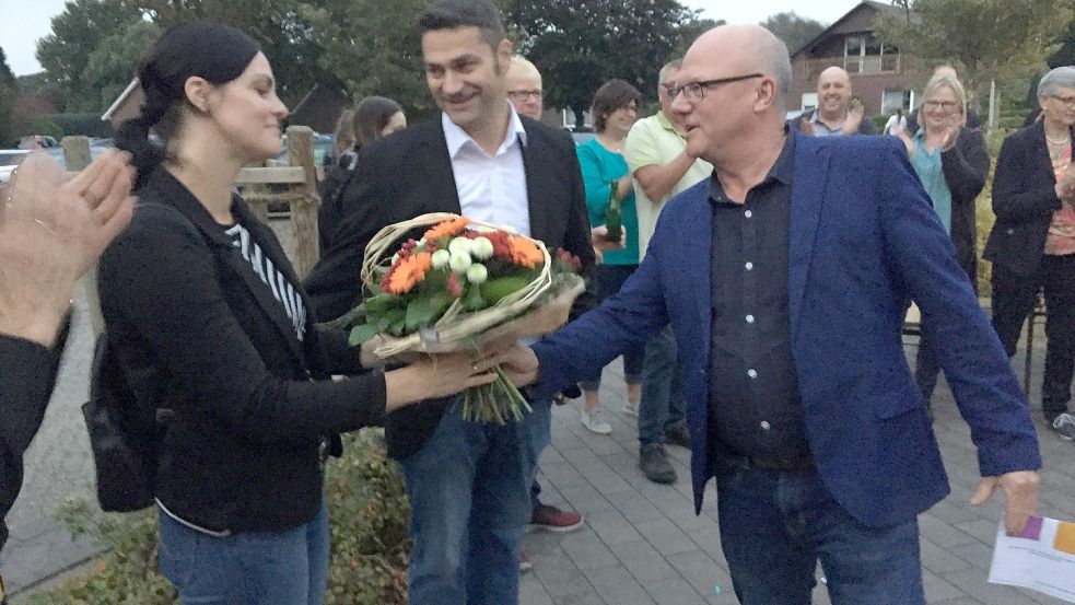 Für die Frau des Siegers, Sabine Busboom, gab es Blumen. Christoph Busboom (Mitte) bekam von dem noch amtierenden Samtgemeindebürgermeister Johann Boelsen den symbolischen Rathausschlüssel. Foto: Kraft