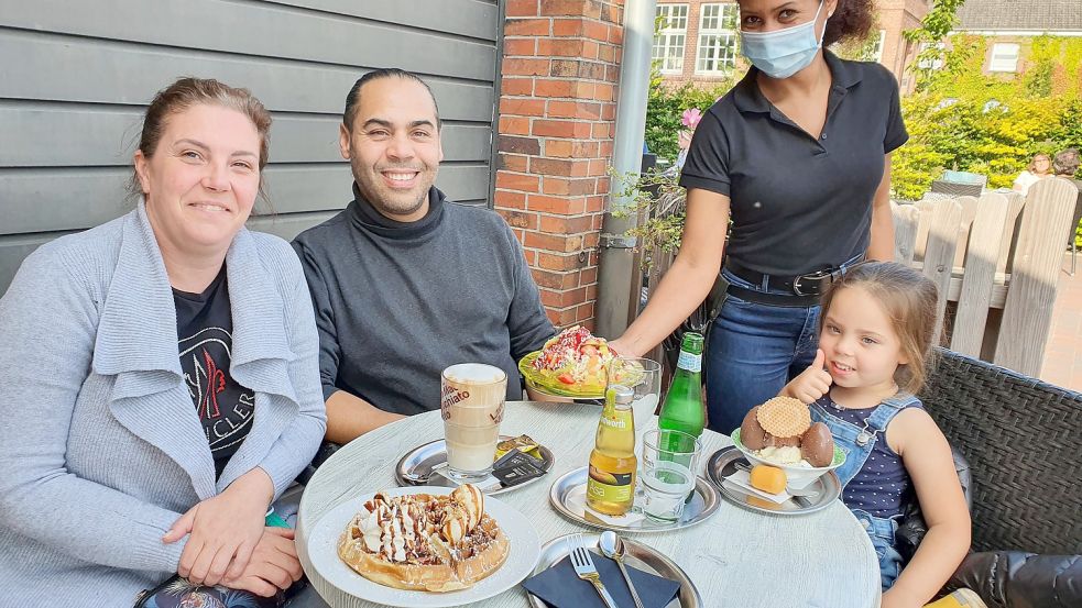 Sandra Giampietro von der Eisdiele Mola in Bunde serviert Debora, Hamid und Ahlalia auf der Terrasse des Eiscafés Eis, Getränke und eine heiße Waffel. Foto: Gettkowski