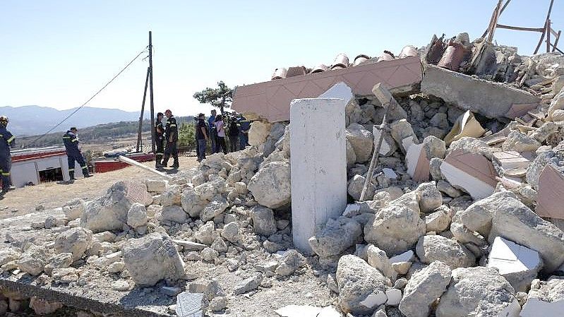 Feuerwehrleute stehen neben einer zerstörten Kirche im Süden der Insel Kreta. Foto: Harry Nakos/AP/dpa