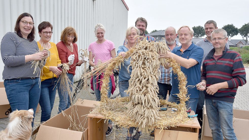 Diese Frauen und Männer des Kolping-Familienkreises I haben die Erntekrone für das am kommenden Sonntag stattfindende Erntedankfest gebunden. Foto: Hellmann