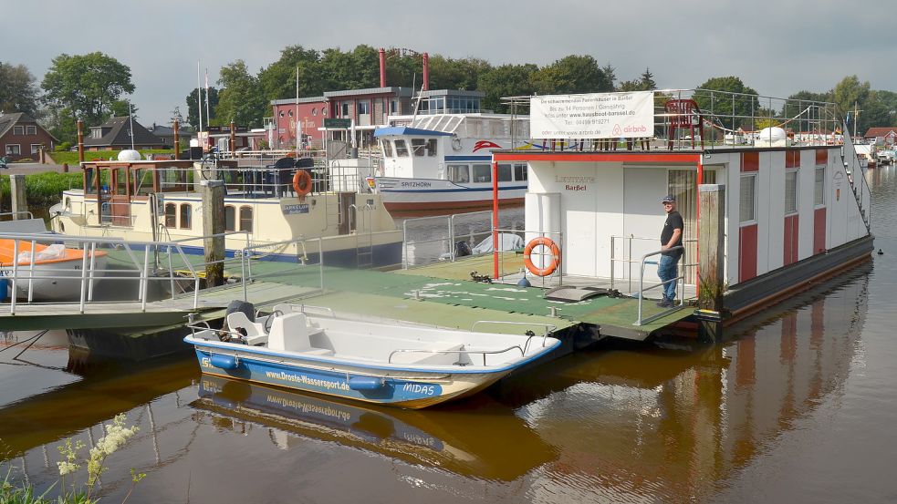 Zwei Hausboote hat die Firma Droste Wassersport im Barßeler Hafen liegen: die Barkeloh, ein klassisches Hausboot holländischen Typs, und die Levitate - hier mit Rüdiger Droste an Bord - die sein Vater Peter Droste nach amerikanischem Vorbild gebaut hat. Die Schiffe sind fahrtüchtig. Sie liegen allerdings fest vertäut am Steg und werden von den Gästen ausschließlich als schwimmendes Ferienhaus genutzt. Fotos: Fertig