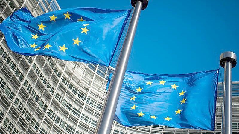 Flaggen der Europäischen Union wehen im Wind vor dem Berlaymont-Gebäude, dem Sitz der Europäischen Kommission. Foto: Arne Immanuel Bänsch/dpa