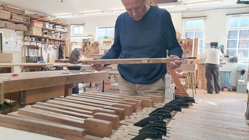 Hendrik Ahrend hält ein Stück der Pedalklaviatur der Orgel. Auch sie wird in der Werkstatt der Firma Ahrend überarbeitet. Unter anderem werden die Messingfeldern erneuert. Foto: Gettkowski