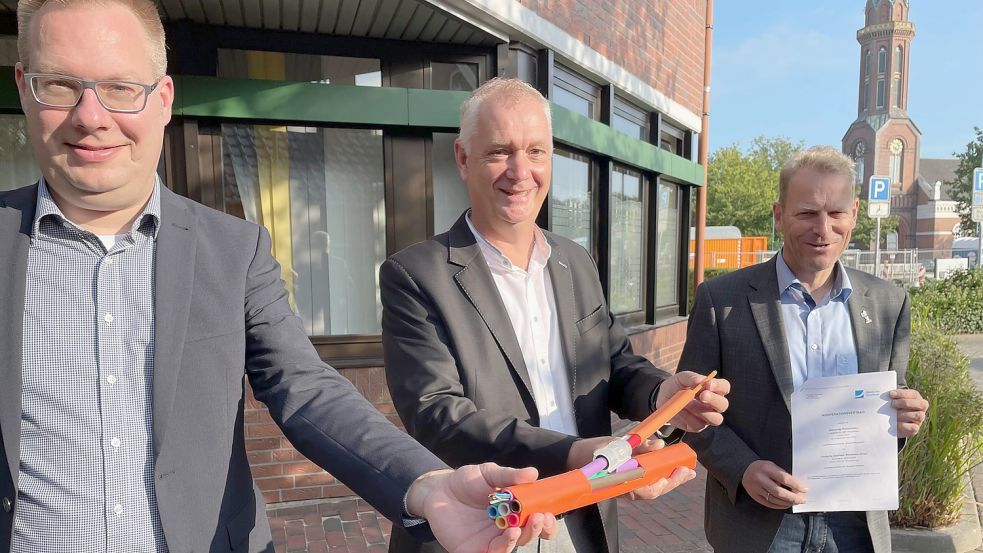 Thomas Breer (von links), Projektleiter der Deutschen Glasfaser, zeigte den Bürgermeistern Günter Harders (Ostrhauderfehn) und Geert Müller (Rhauderfehn) ein Stück der Hülsen, in denen die Glasfasern - zehnmal dünner als ein Haar - verlegt werden. Foto: Janßen
