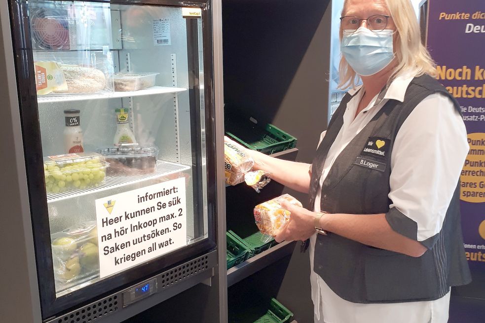 Mitarbeiterin Brigitte Loger befüllt in Weener das "Zu schade für die Tonne"-Regal regelmäßig mit Lebensmitteln aus dem Trockensortiment. Foto: Edeka Minden-Hannover