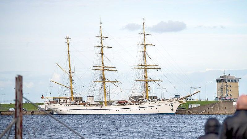 Spaziergänger beobachten die „Gorch Fock“ im Marinehafen. Foto: Sina Schuldt/dpa