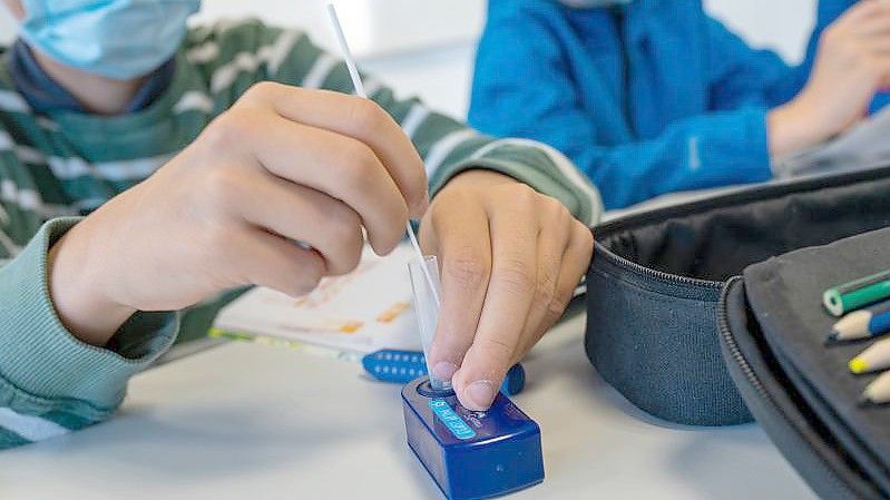 Münchner Schüler machen zu Beginn des Unterrichts einen Covid-19-Schnelltest. Die 7-Tage-Inzidenz in Deutschland ist am vierten Tag in Folge etwas gestiegen. Foto: Peter Kneffel/dpa