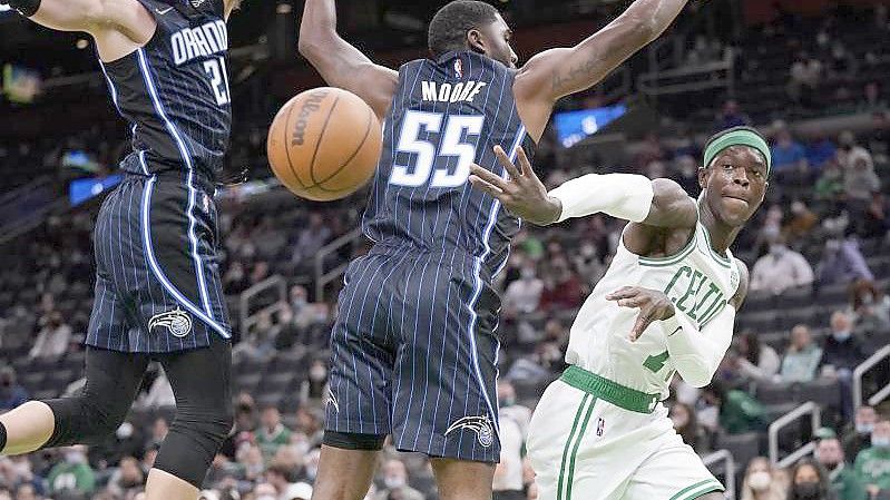 E'Twaun Moore (M/55) und Moritz Wagner (21/l)) von Orlando Magic blocken Celtics-Spieler Dennis Schröder. Foto: Charles Krupa/AP/dpa