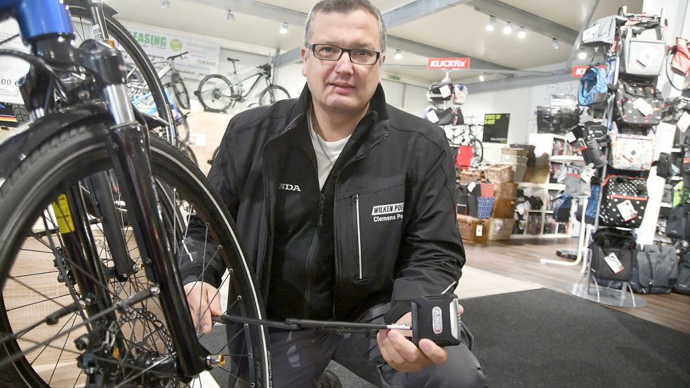 Fahrradhändler Clemens Poelker zeigt ein Schloss. Foto: Hellmers